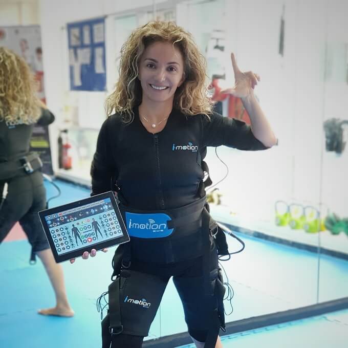 TrainWithUs EMS Personal Training Client taking a picture while holding I-motion EMS Training Device