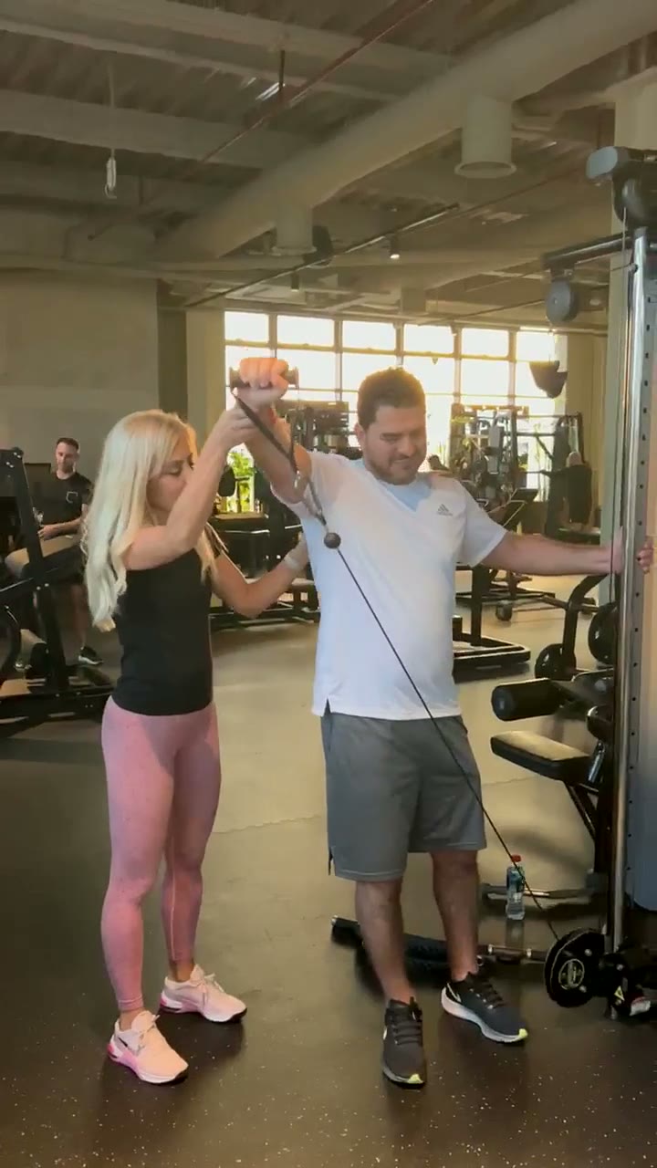 Jovana coaching a client on a cable raise in Dubai