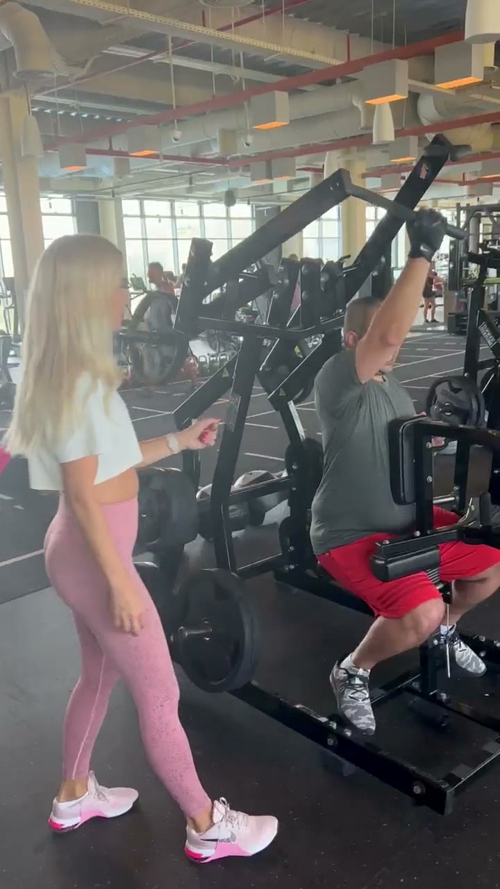 Jovana coaching a client on a chest press machine in Dubai