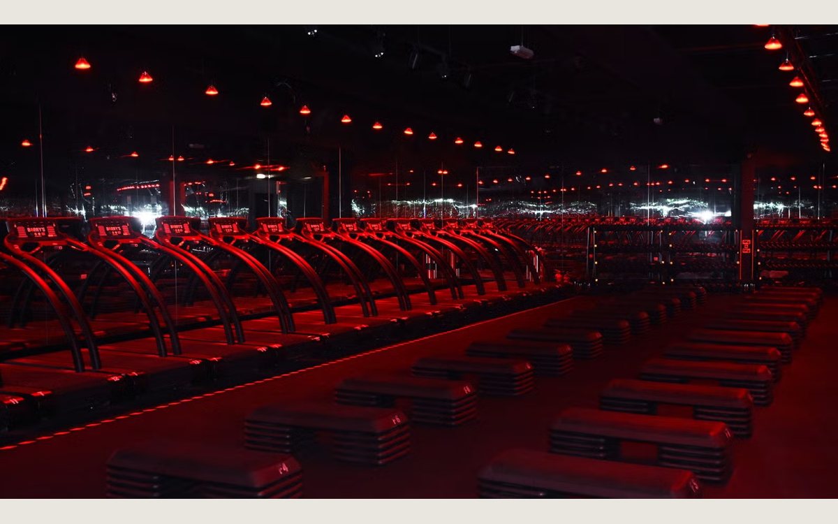 The Red Room at Barrys DIFC, a row of treadmills and benches under red lighting